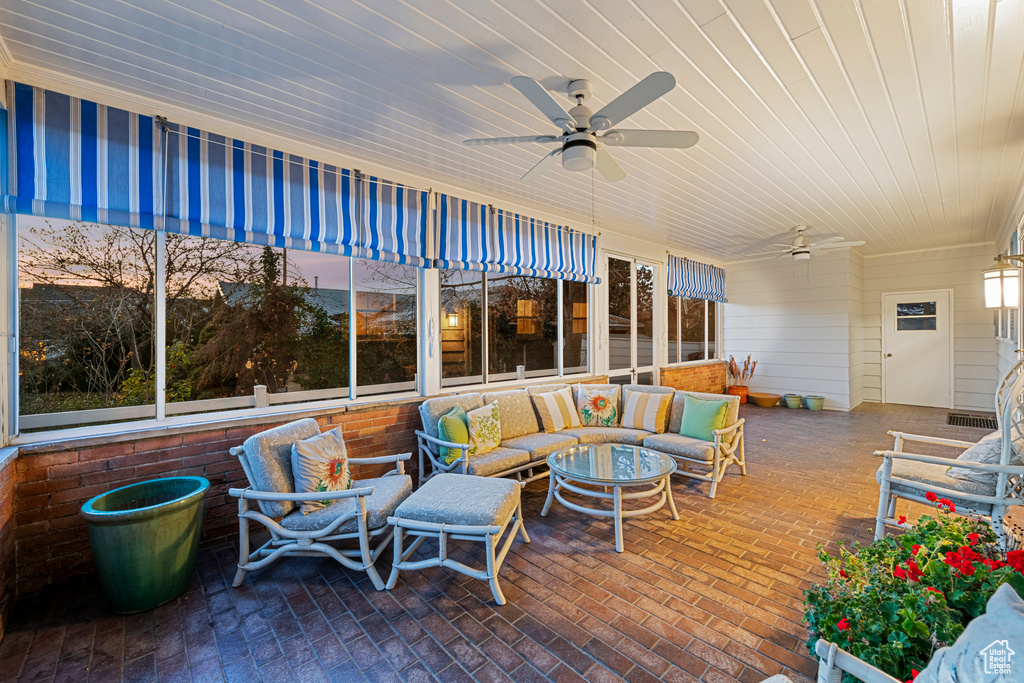 Sunroom featuring wood ceiling and ceiling fan