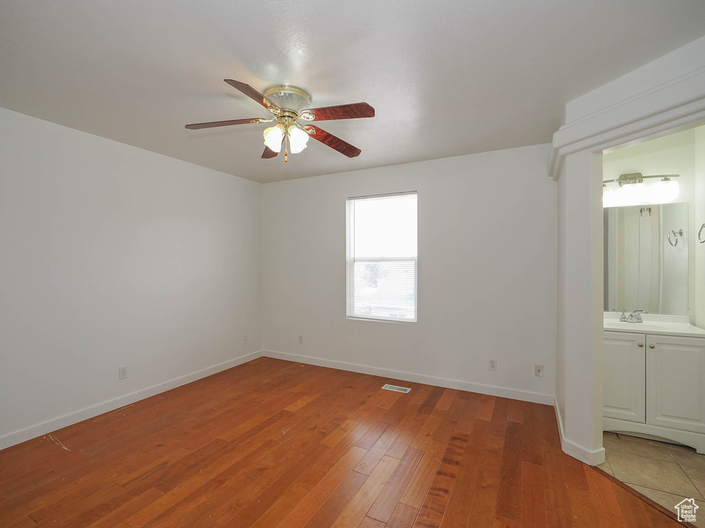 Unfurnished room featuring sink, ceiling fan, and dark hardwood / wood-style flooring