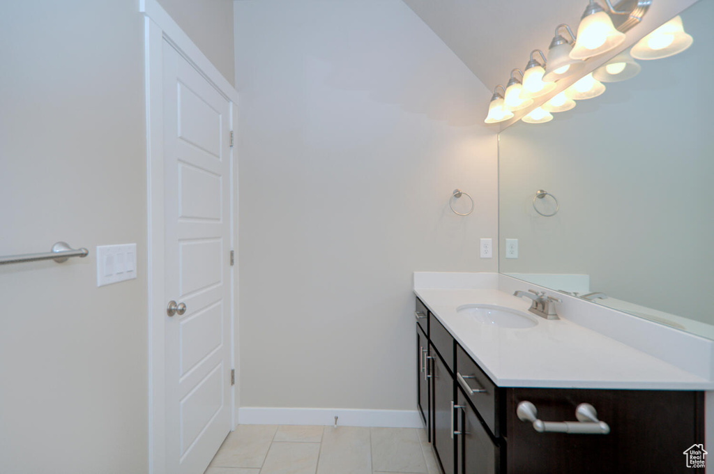 Bathroom with vanity, tile floors, and vaulted ceiling