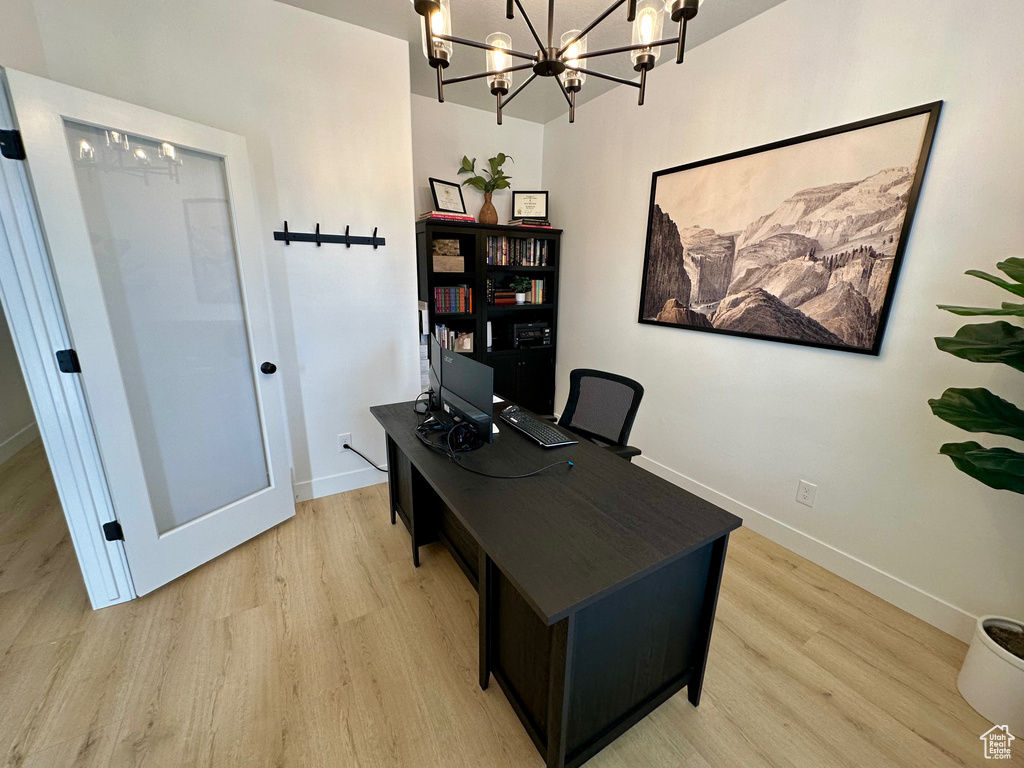 Office area with an inviting chandelier and light hardwood / wood-style floors