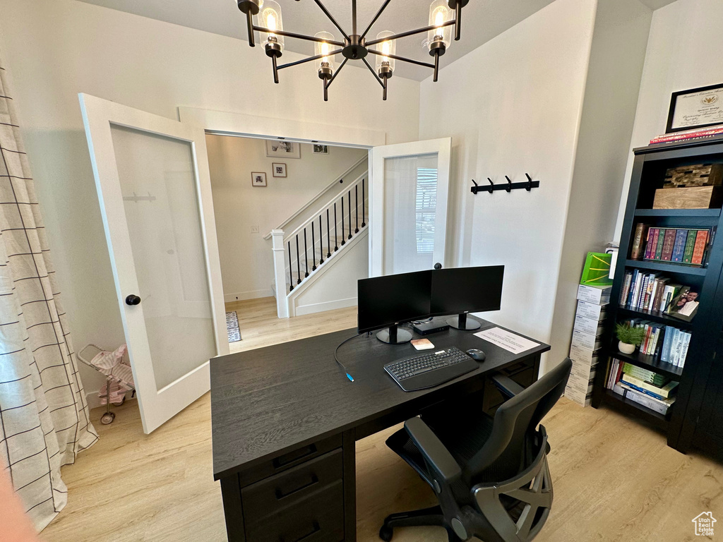 Office featuring light hardwood / wood-style floors and an inviting chandelier