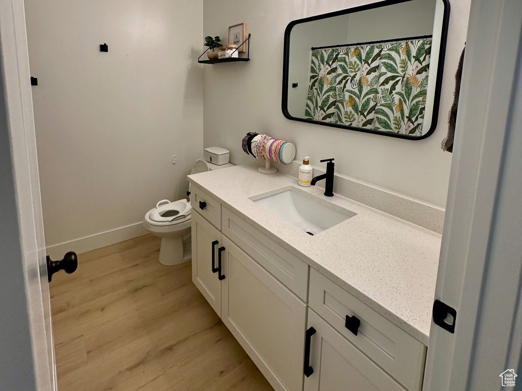 Bathroom with toilet, vanity, a textured ceiling, and wood-type flooring