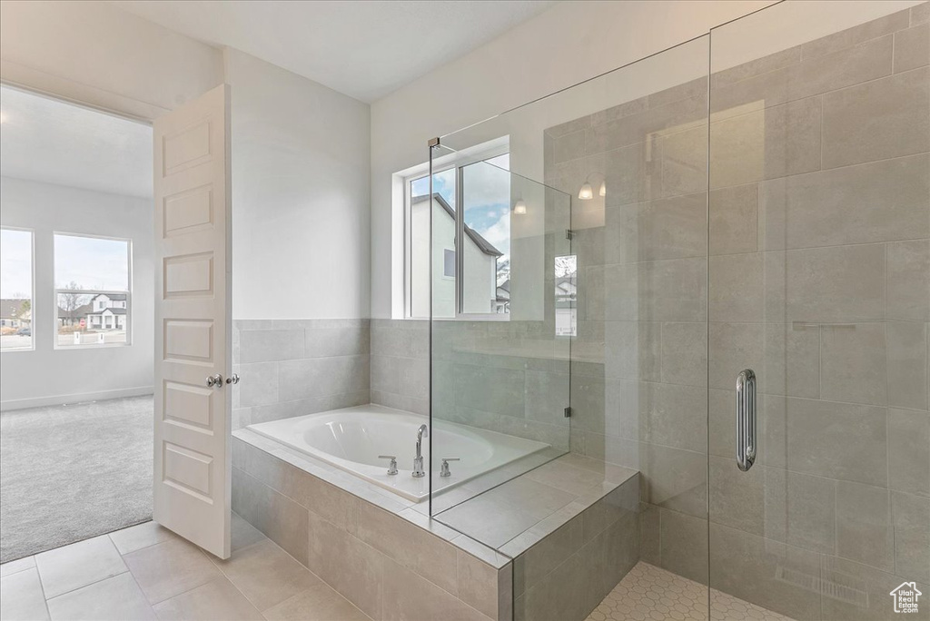 Bathroom with a healthy amount of sunlight, plus walk in shower, and tile flooring
