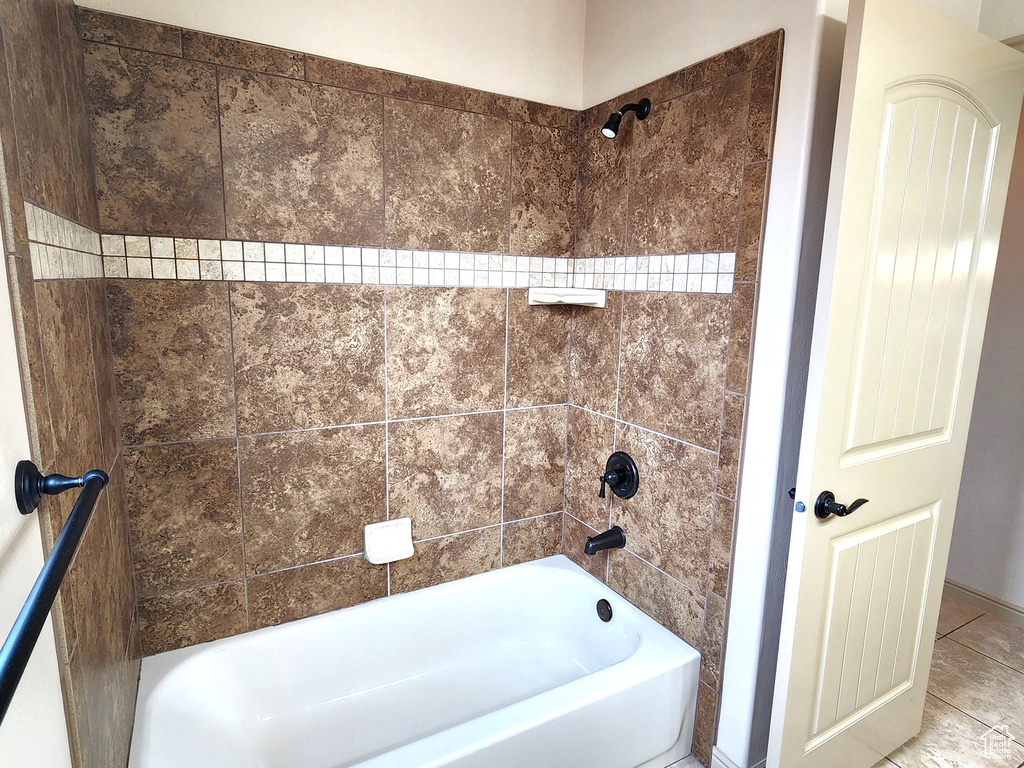 Bathroom with tiled shower / bath combo and tile floors