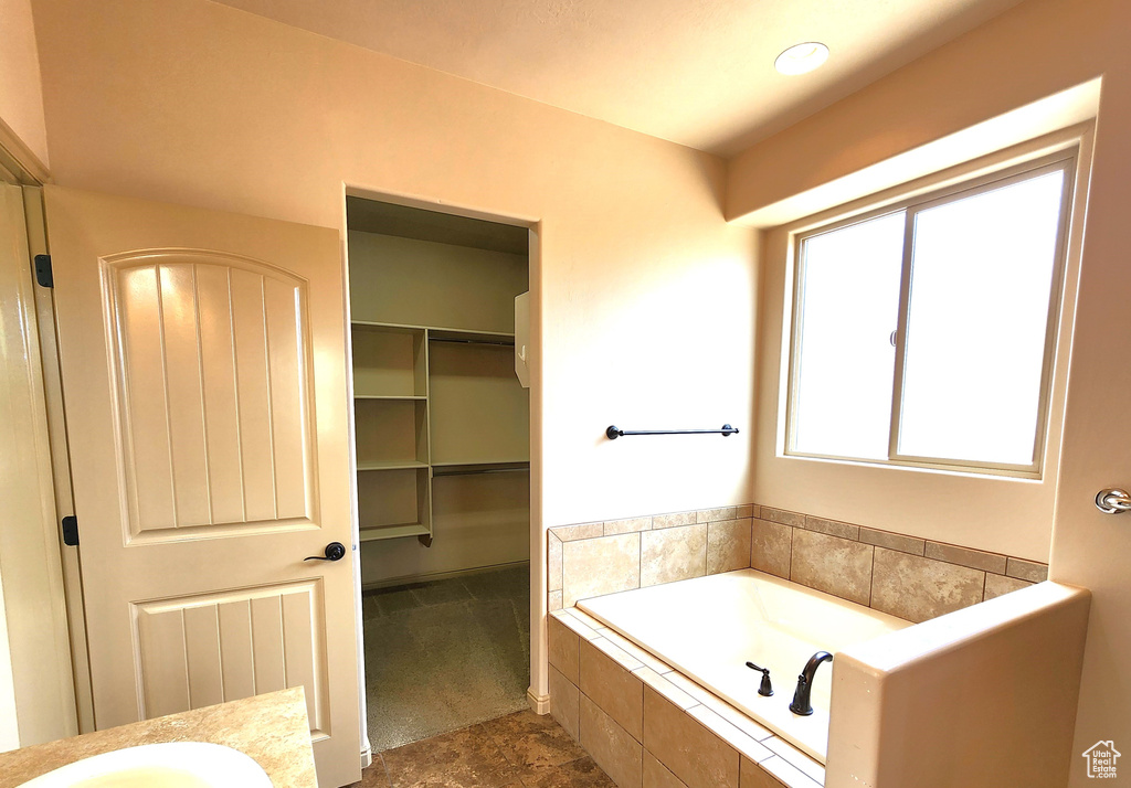 Bathroom featuring tiled bath and tile flooring