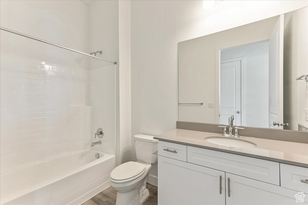 Full bathroom featuring shower / washtub combination, toilet, hardwood / wood-style flooring, and vanity
