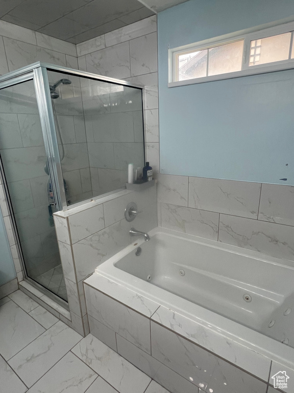 Bathroom with tile flooring and independent shower and bath