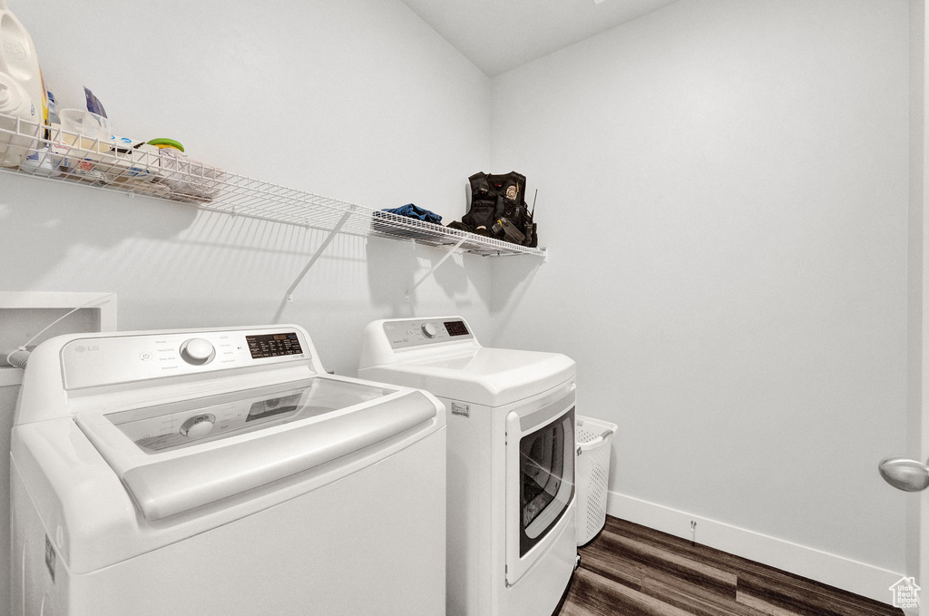 Clothes washing area with washing machine and dryer, dark wood-type flooring, and hookup for a washing machine