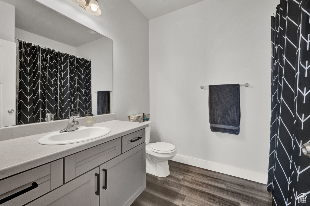 Bathroom featuring toilet, hardwood / wood-style floors, and vanity