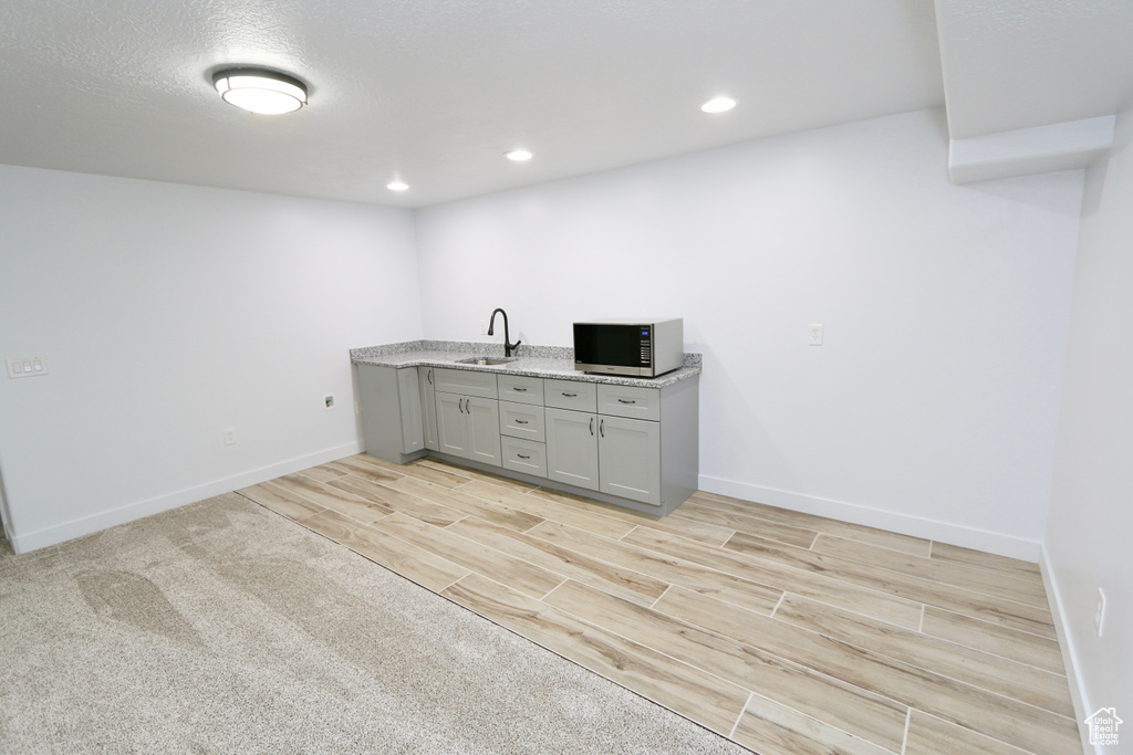 Unfurnished office featuring light colored carpet and sink