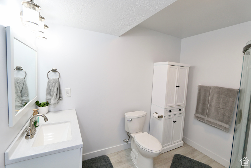 Bathroom featuring toilet, a textured ceiling, vanity, and wood-type flooring