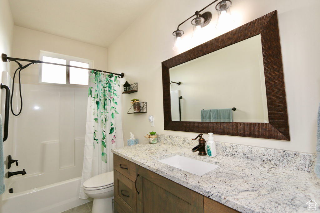 Full bathroom with toilet, tile flooring, vanity, and shower / bath combo with shower curtain