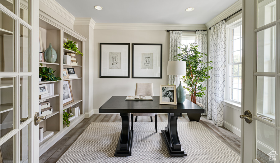 Office with a healthy amount of sunlight, french doors, dark hardwood / wood-style flooring, and ornamental molding
