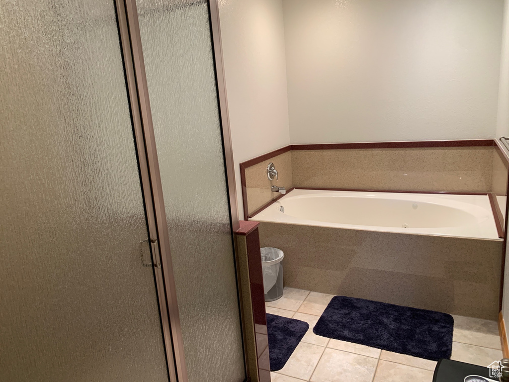 Bathroom featuring tile flooring and tiled bath