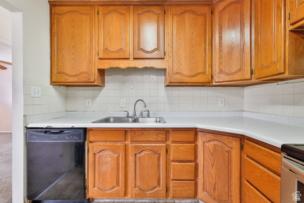 Kitchen featuring sink, black dishwasher, tasteful backsplash, and carpet floors