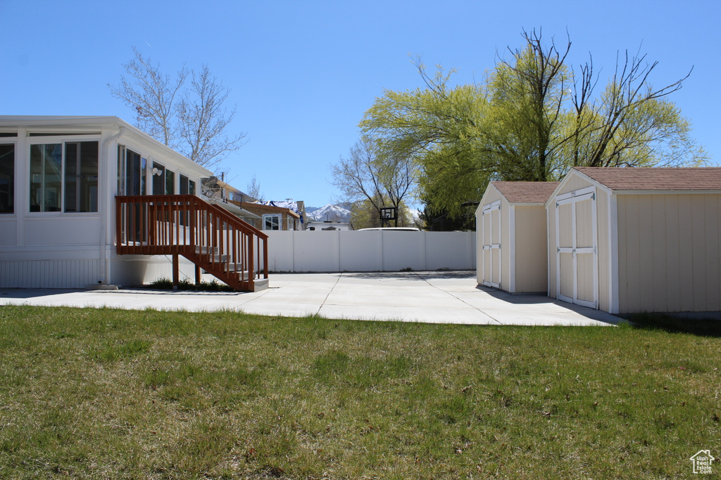 View of yard with a storage shed and a patio area
