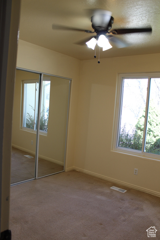 Unfurnished bedroom featuring ceiling fan, carpet flooring, and a closet