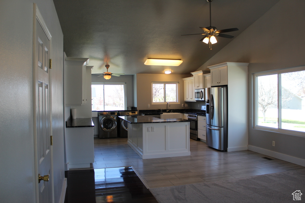 Kitchen with white cabinets, a center island, stainless steel appliances, and ceiling fan