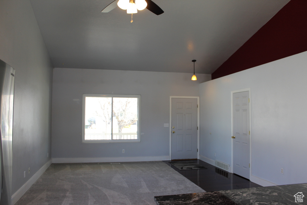 Unfurnished room with dark carpet, vaulted ceiling, and ceiling fan