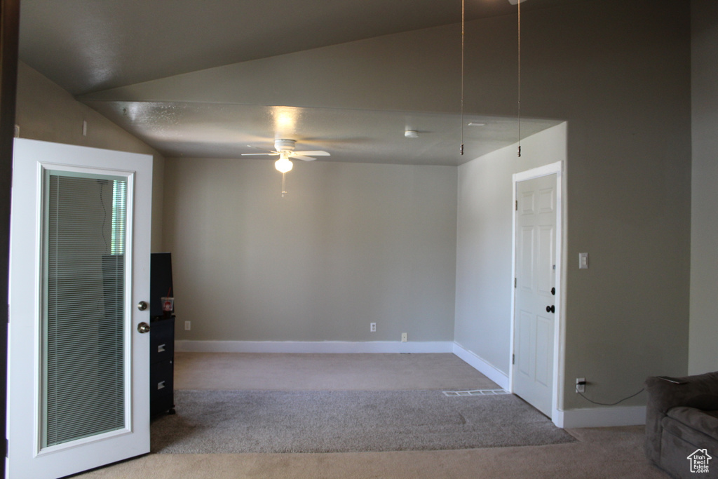 Unfurnished room with light colored carpet, vaulted ceiling, and ceiling fan