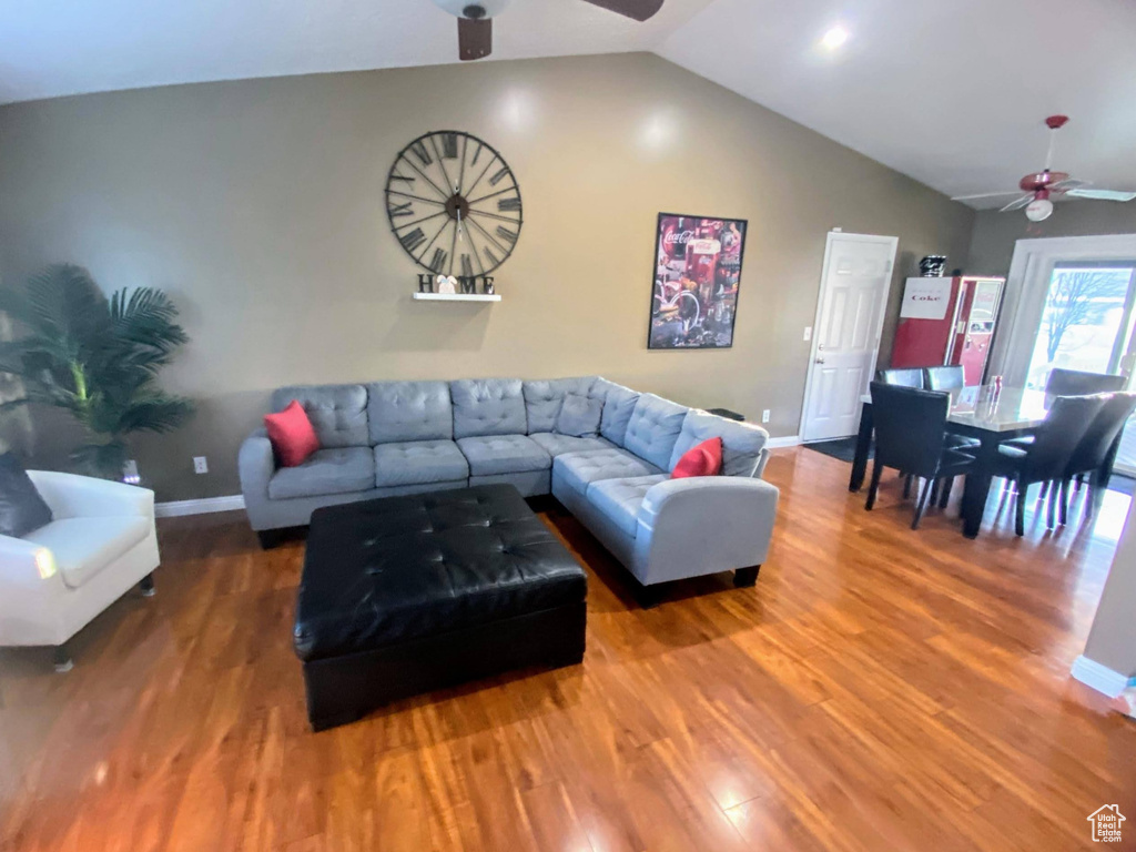 Living room featuring hardwood / wood-style floors, ceiling fan, and vaulted ceiling