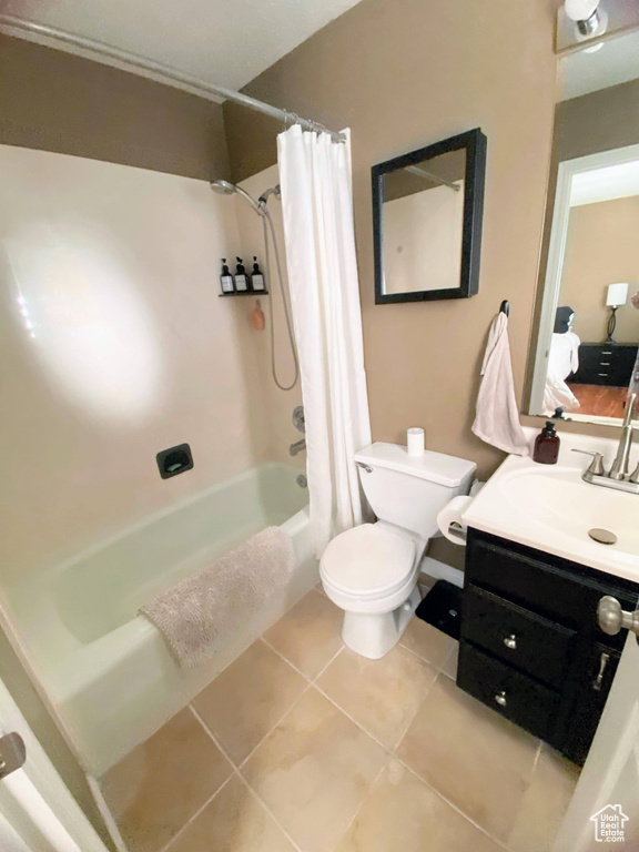 Full bathroom with oversized vanity, crown molding, toilet, tile flooring, and shower / tub combo with curtain