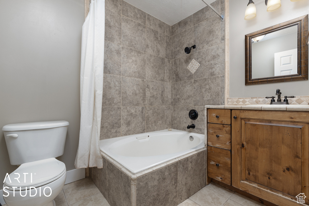 Full bathroom featuring toilet, tile floors, vanity, and shower / bath combo with shower curtain