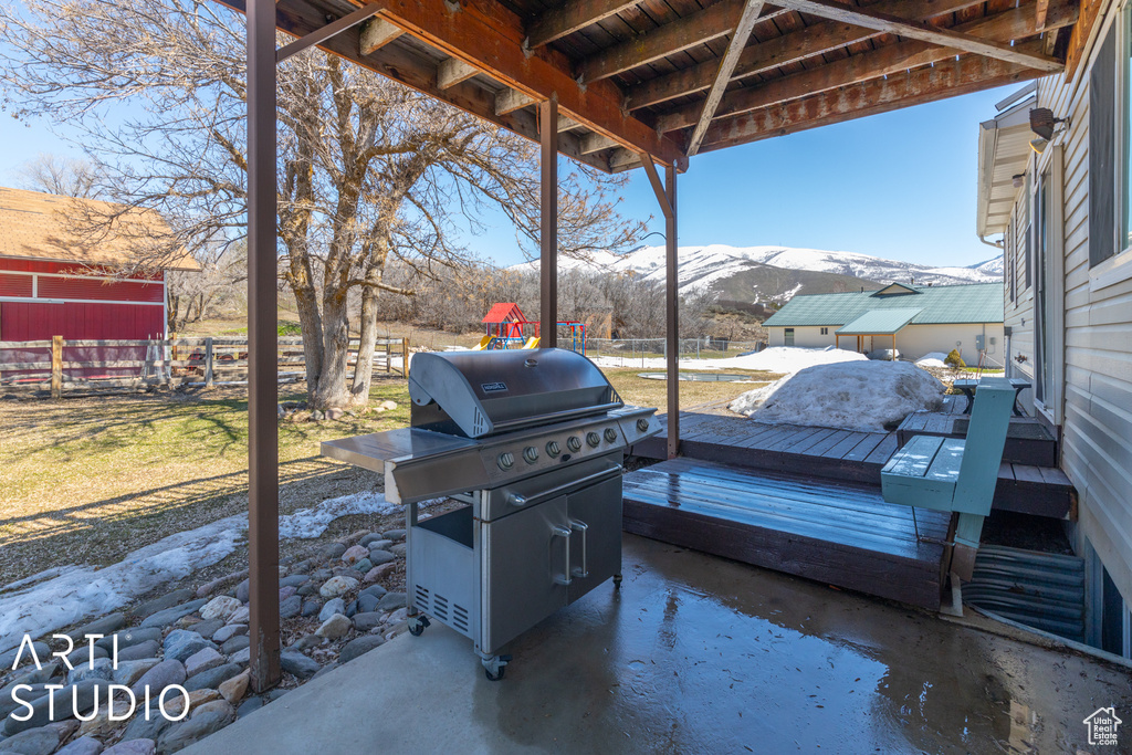 View of patio with a deck with mountain view and grilling area