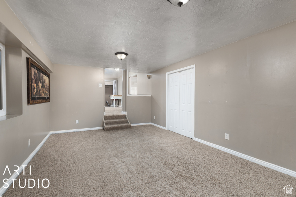 Interior space featuring a textured ceiling and carpet floors