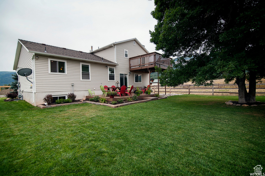 Back of house with a yard and a wooden deck