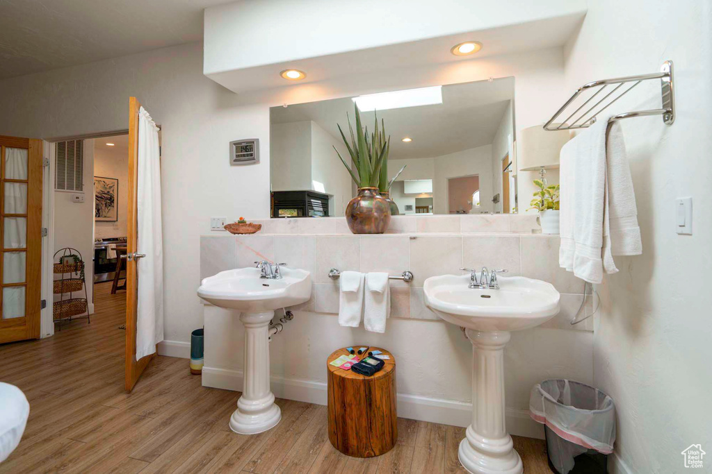 Bathroom featuring hardwood / wood-style floors and tasteful backsplash