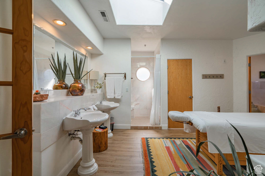 Bathroom featuring hardwood / wood-style floors and a skylight
