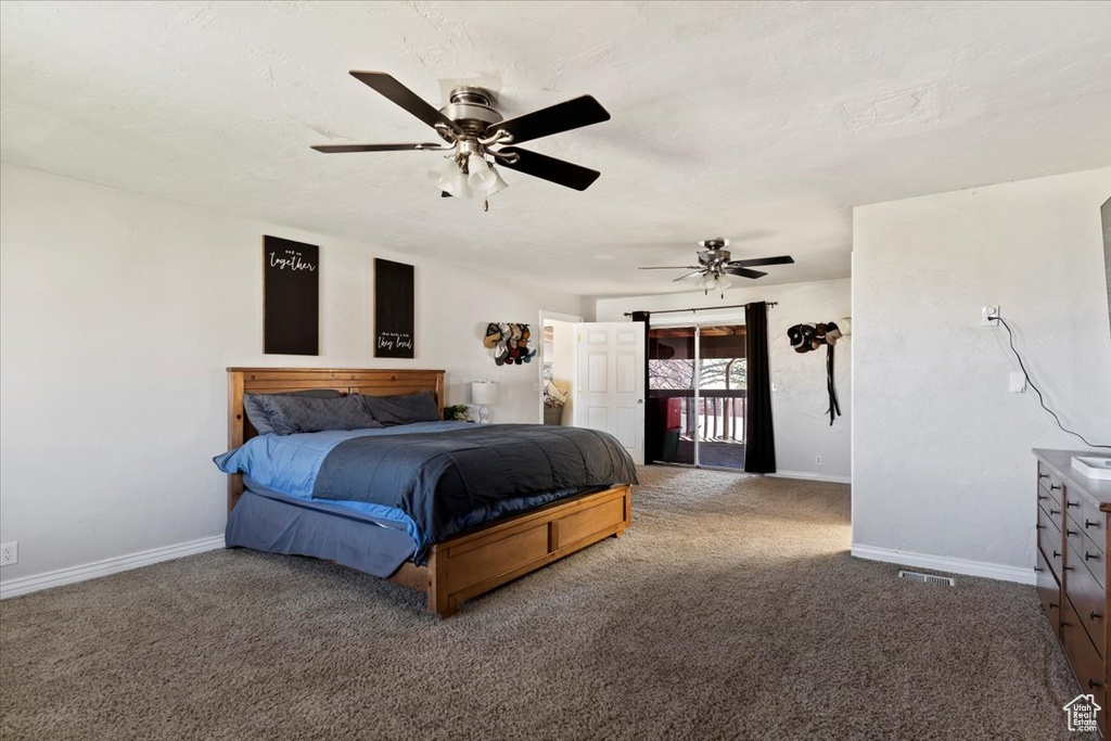 Bedroom with ceiling fan, access to exterior, and dark colored carpet
