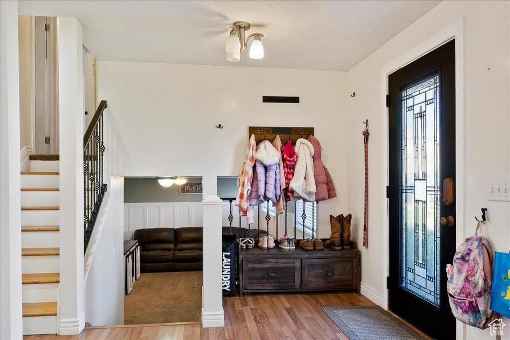 Foyer entrance with an inviting chandelier and light hardwood / wood-style flooring