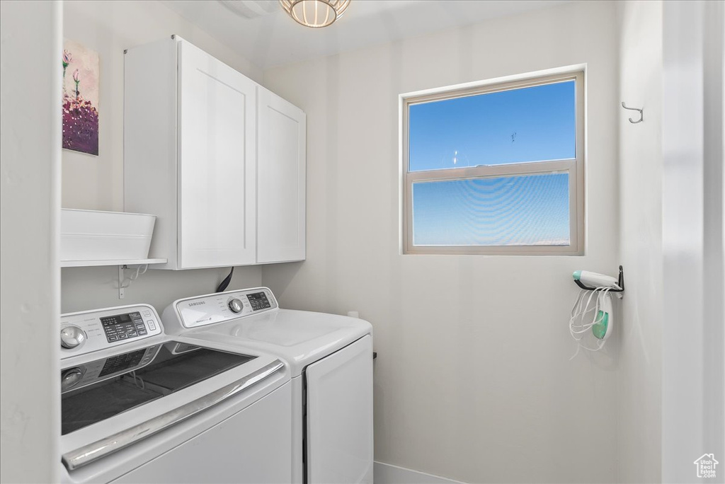 Laundry room featuring cabinets and washing machine and dryer