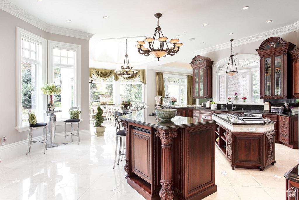 Kitchen featuring a chandelier, decorative light fixtures, light tile flooring, and a center island