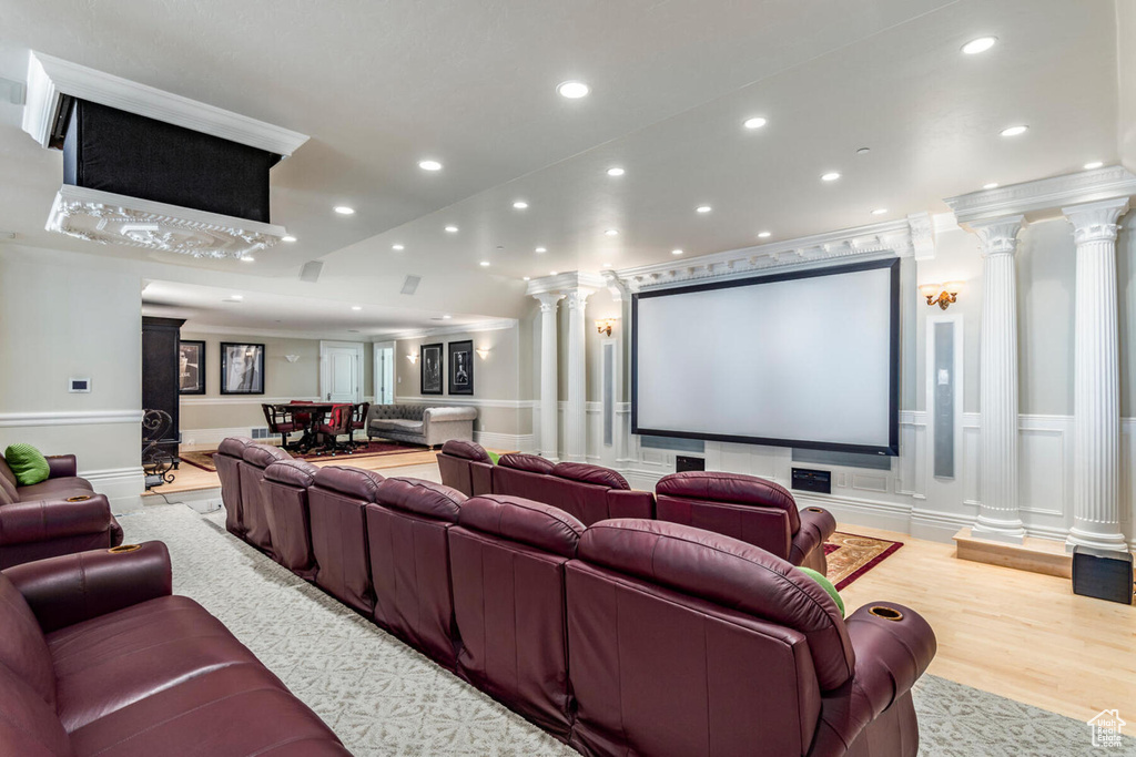 Home theater with decorative columns and light wood-type flooring