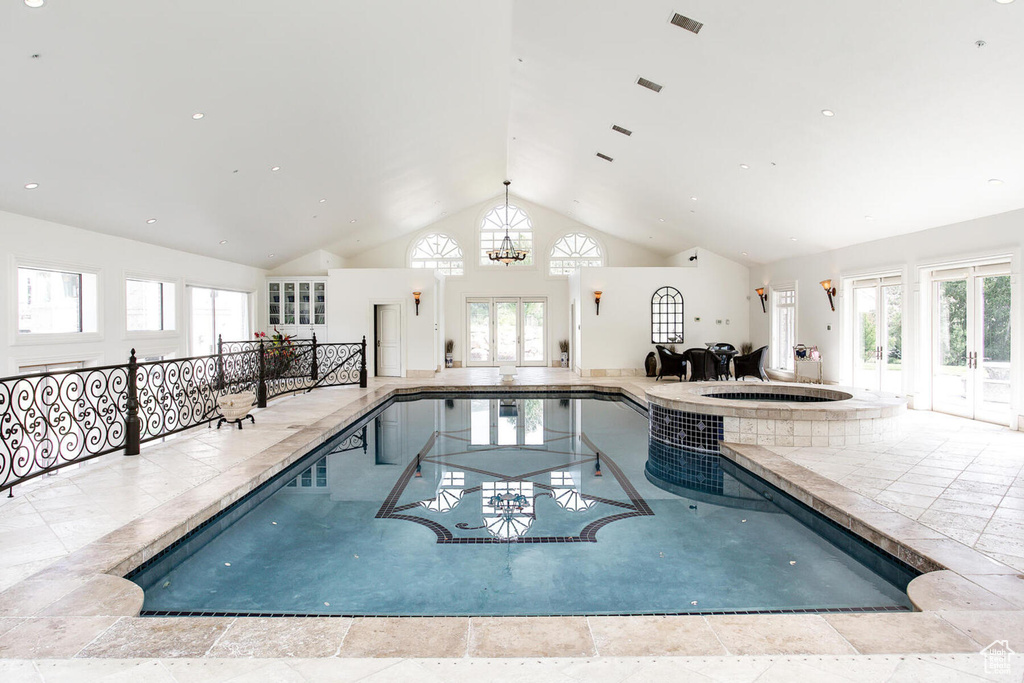 View of swimming pool featuring a notable chandelier and an indoor hot tub