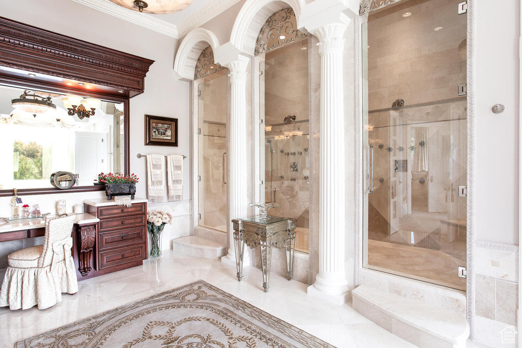 Bathroom featuring vanity, a shower with shower door, and decorative columns