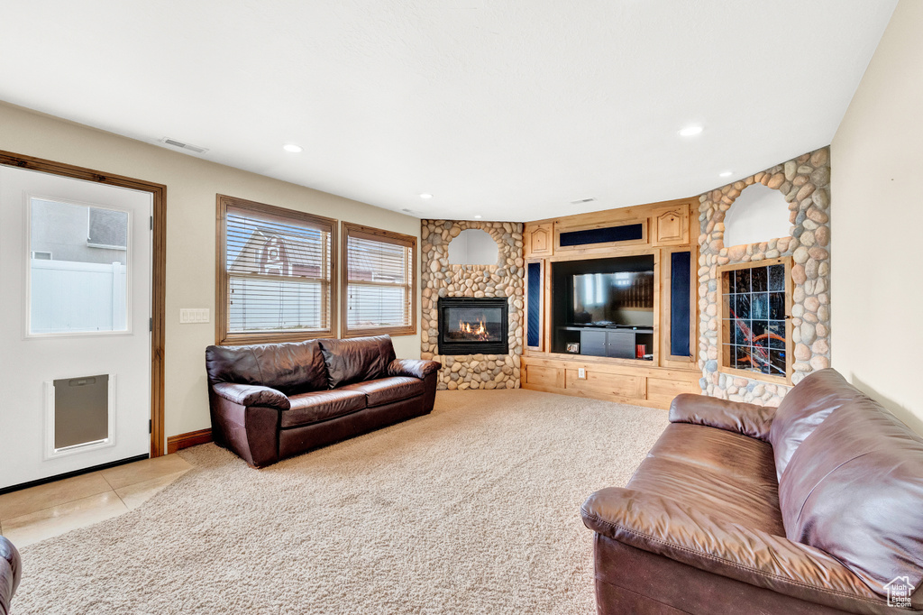 Carpeted living room featuring built in shelves and a fireplace