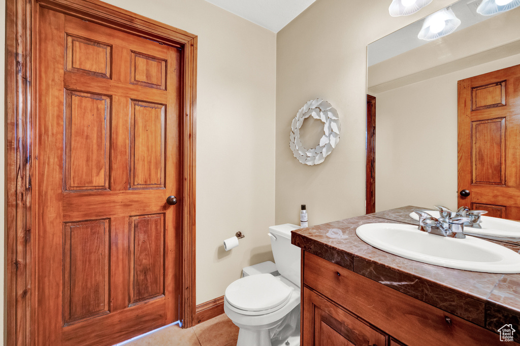 Bathroom featuring tile flooring, toilet, and oversized vanity