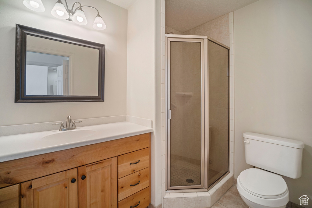 Bathroom featuring toilet, tile flooring, an enclosed shower, and vanity