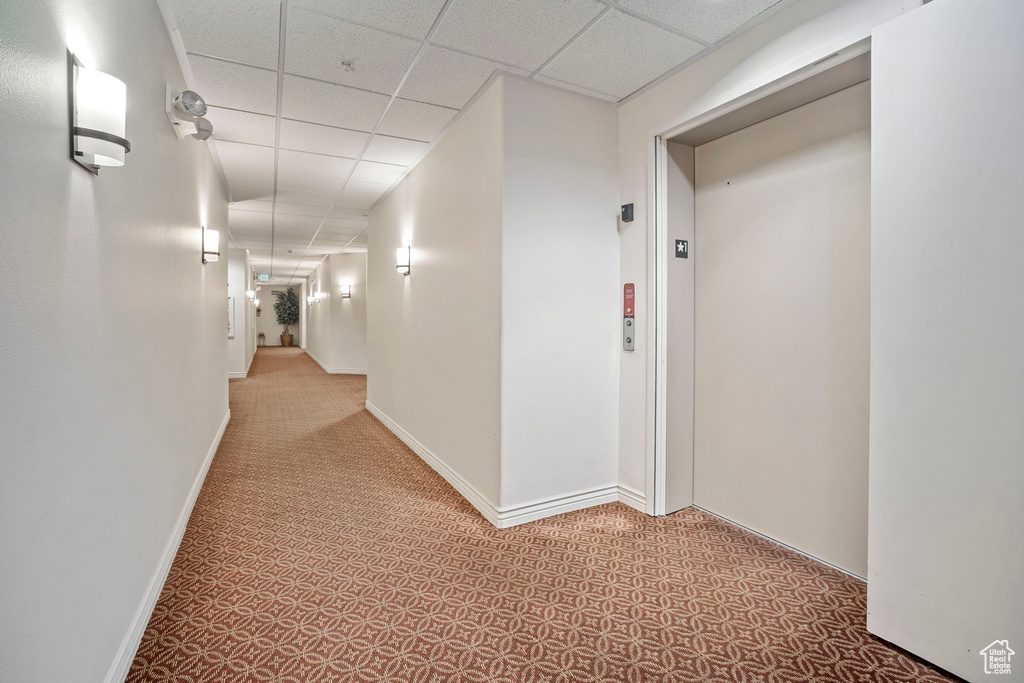 Corridor with a paneled ceiling and elevator