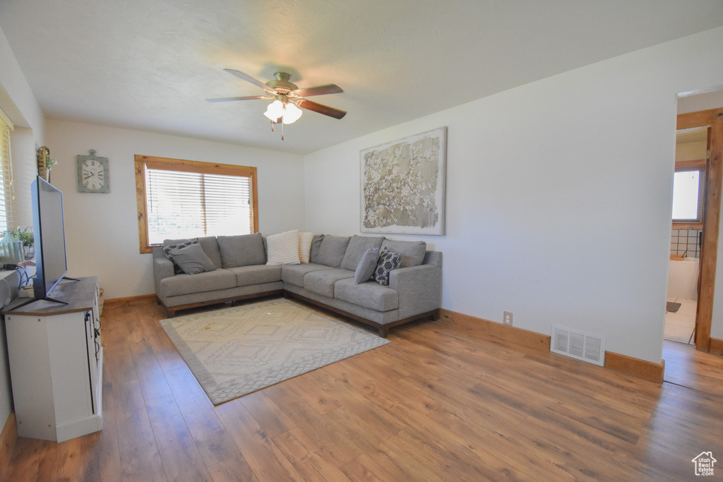 Living room with ceiling fan and hardwood / wood-style flooring