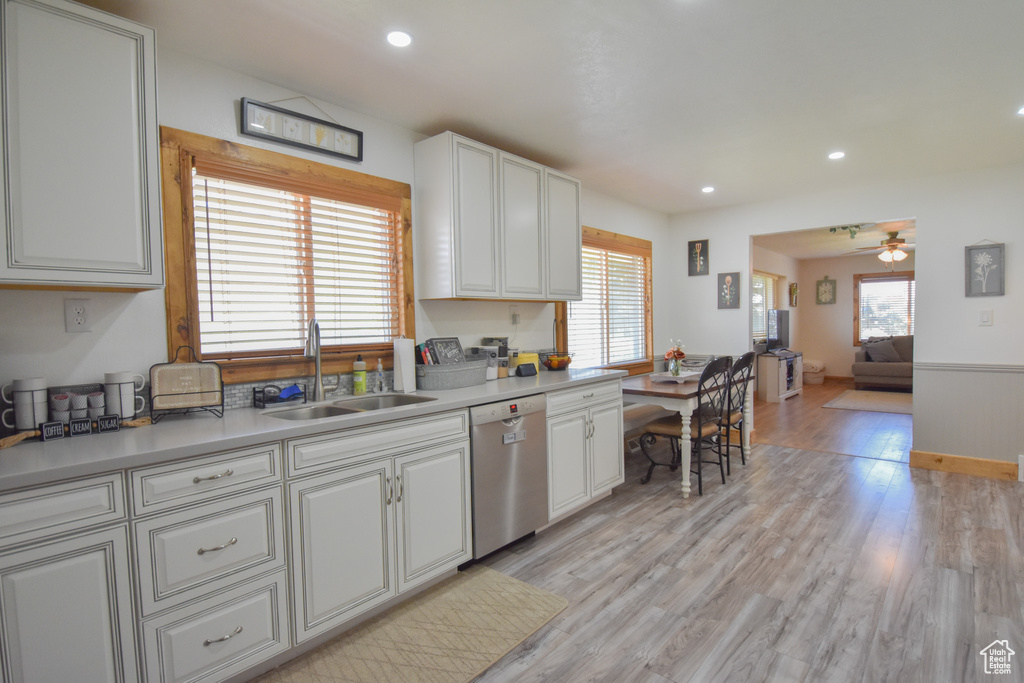 Kitchen with light hardwood / wood-style floors, ceiling fan, sink, and dishwasher
