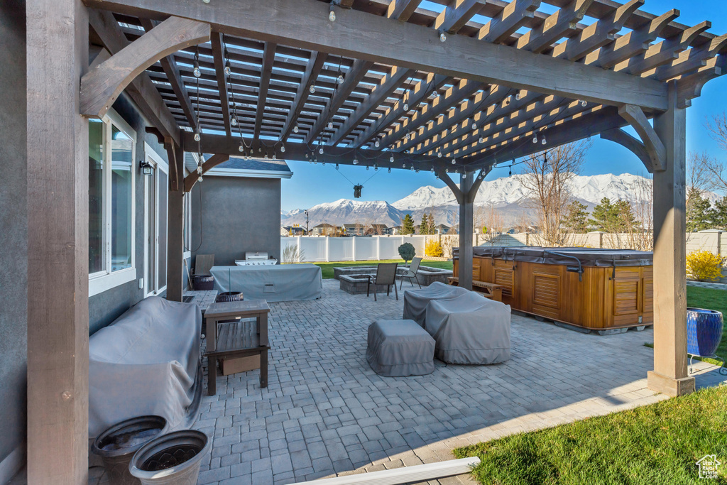 View of patio / terrace with a pergola, a mountain view, and a hot tub
