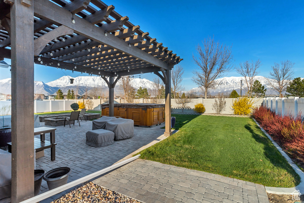 View of yard with an outdoor fire pit, a pergola, a patio area, a mountain view, and a hot tub