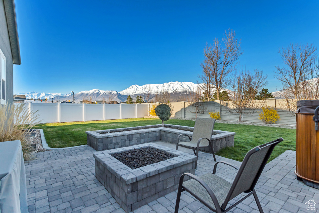 View of terrace featuring an outdoor fire pit and a mountain view