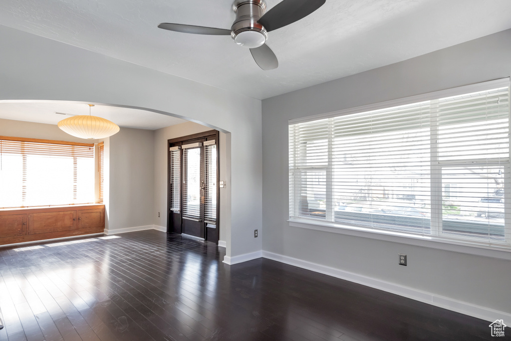 Empty room featuring dark hardwood / wood-style flooring and ceiling fan