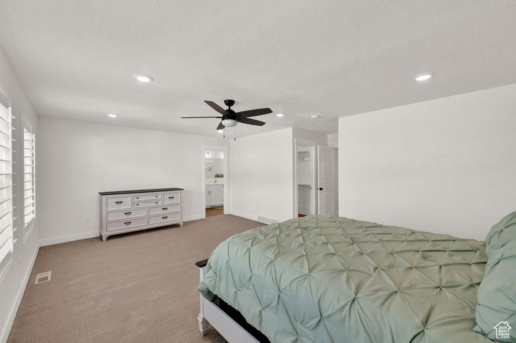 Bedroom featuring ceiling fan, carpet, and a textured ceiling